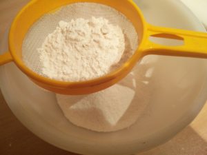 Sifting the flour to remove lumps