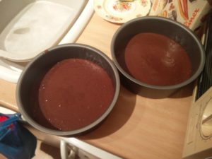 Two cake pans with half of the cake mixture in each