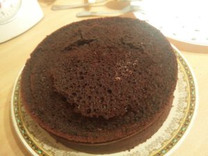 The third layer of cake added, looking like it is smiling