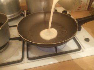The batter being poured into the frying pan