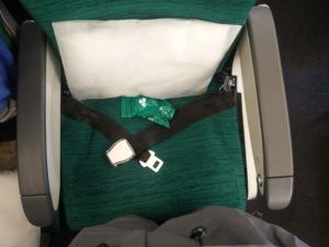 My seat showing the pillow and two pairs of headphones